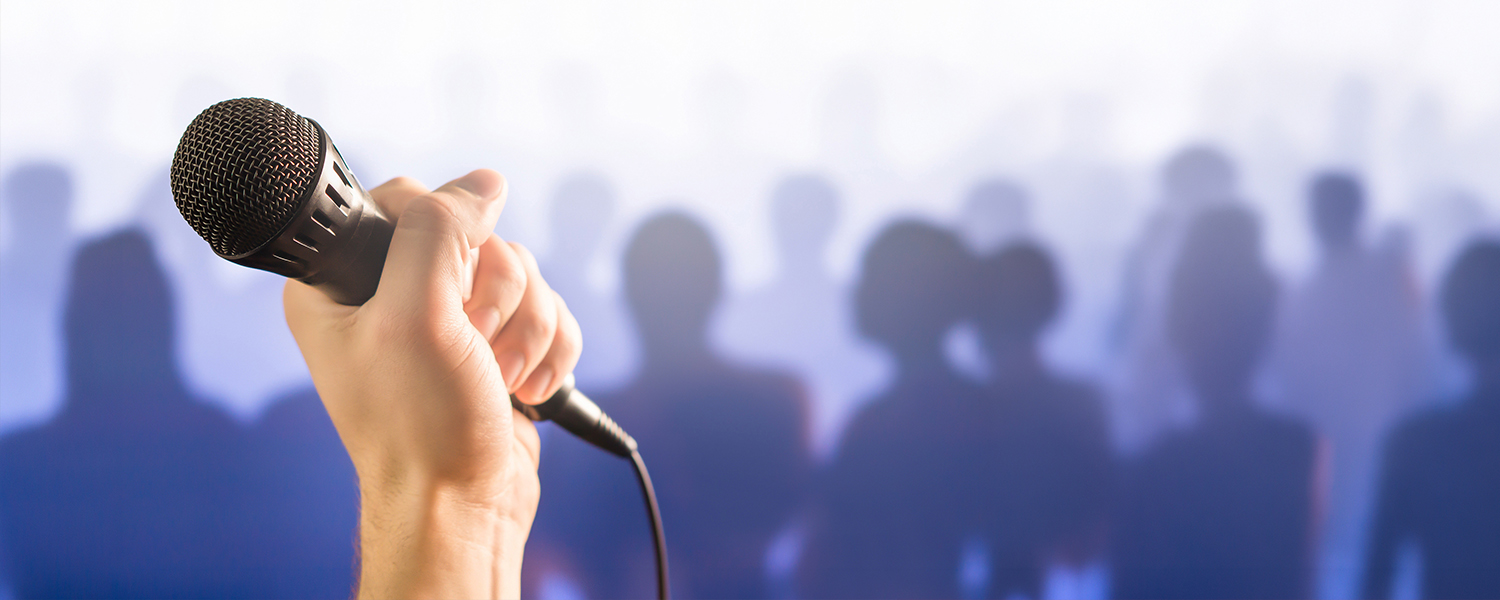 Microphone with silhuoettes of people in the background